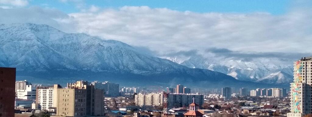 Edificios residenciales de Santiago con la cordillera nevada al fondo